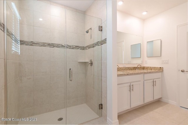 bathroom with tile patterned flooring, vanity, and an enclosed shower