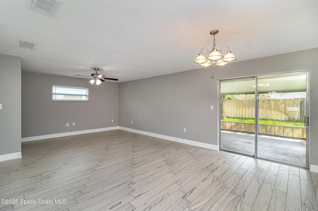 empty room featuring light wood finished floors, visible vents, ceiling fan with notable chandelier, and baseboards