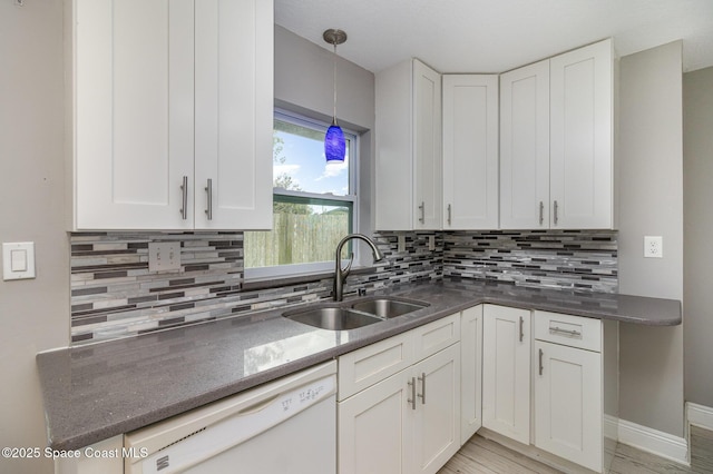 kitchen with a sink, decorative light fixtures, dishwasher, and white cabinets