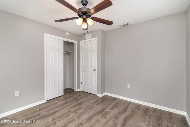 unfurnished bedroom with visible vents, baseboards, and wood finished floors