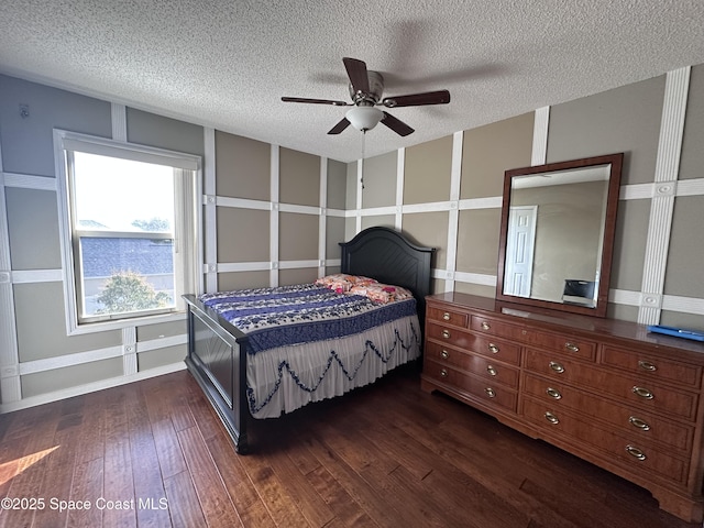 bedroom featuring ceiling fan, dark wood-type flooring, and a textured ceiling