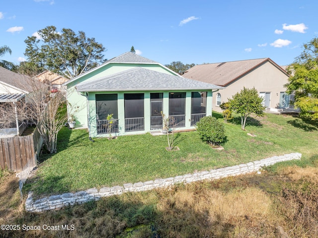 rear view of property with a yard and a sunroom