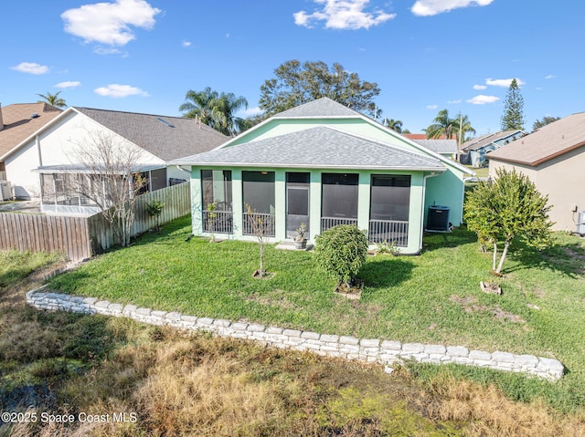 rear view of property with a sunroom, a yard, and central air condition unit