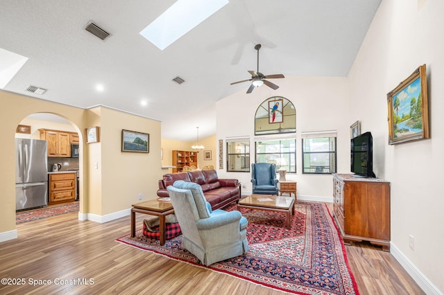 living room featuring ceiling fan, high vaulted ceiling, and light hardwood / wood-style floors