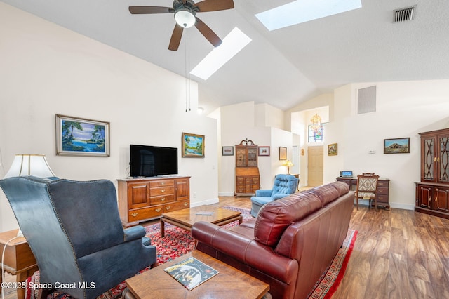 living room with hardwood / wood-style flooring, high vaulted ceiling, ceiling fan, and a skylight