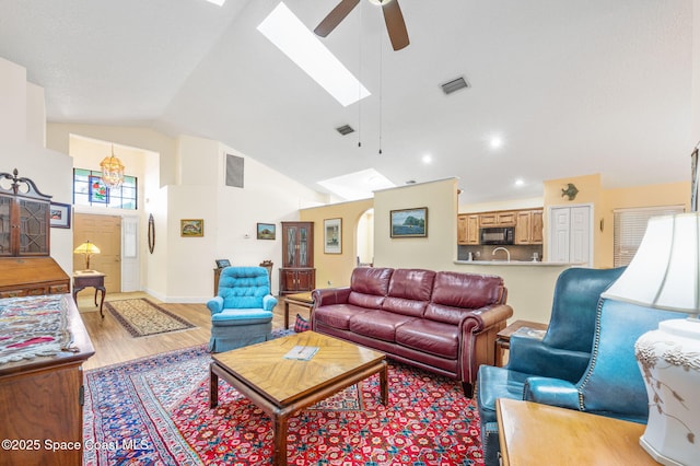 living room featuring ceiling fan, high vaulted ceiling, and light wood-type flooring