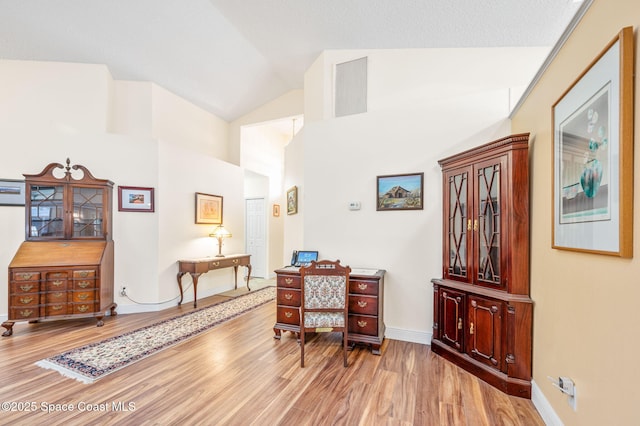 interior space with hardwood / wood-style flooring and lofted ceiling