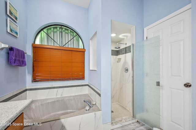 bathroom featuring plus walk in shower and vanity