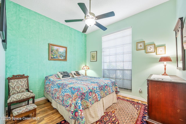 bedroom with ceiling fan and light wood-type flooring