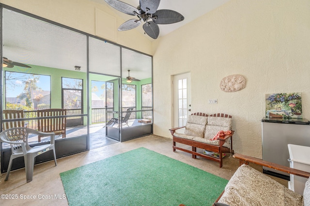 living room with a high ceiling, a wealth of natural light, and ceiling fan