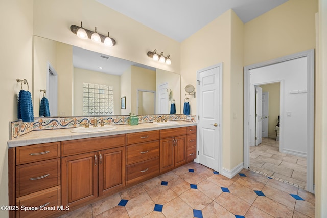 bathroom with tasteful backsplash, tile patterned floors, and vanity