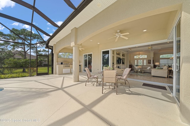 sunroom featuring ceiling fan and decorative columns