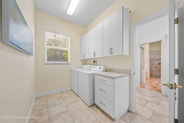 laundry room featuring cabinets, washing machine and dryer, and light tile patterned floors