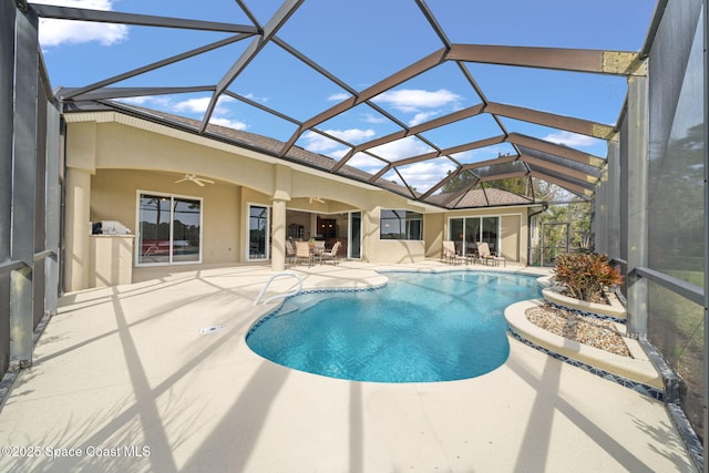 view of pool featuring a patio, ceiling fan, and glass enclosure