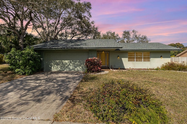 single story home featuring a yard and a garage