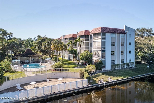 view of property with a community pool and a water view