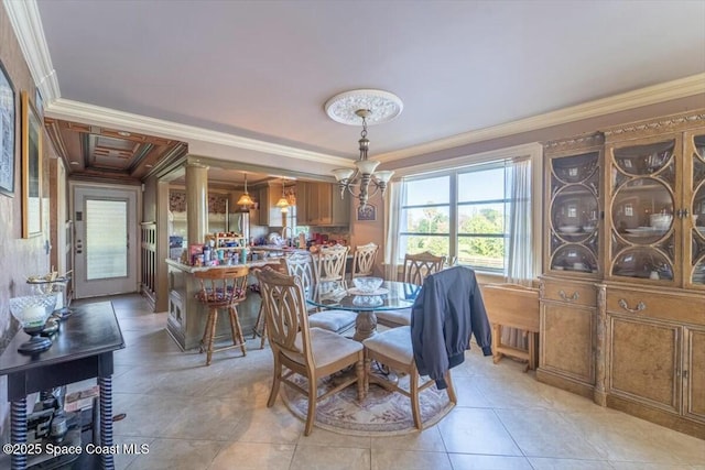 dining room with ornamental molding, light tile patterned flooring, and a notable chandelier