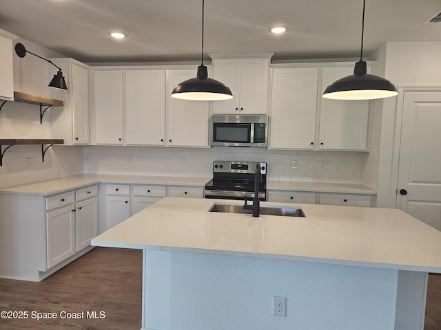 kitchen featuring stainless steel appliances, white cabinetry, and pendant lighting