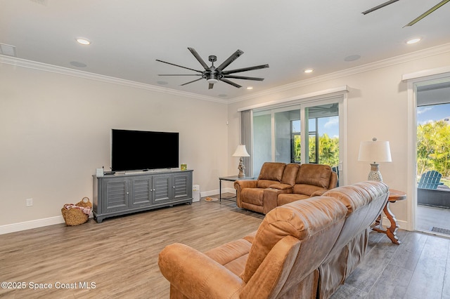 living room featuring a wealth of natural light, ornamental molding, and light wood-type flooring