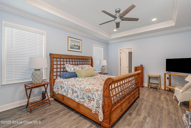 bedroom featuring crown molding, wood-type flooring, and a raised ceiling