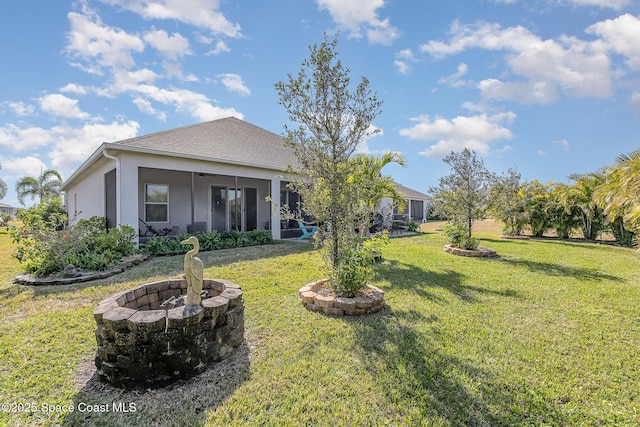 view of yard with a fire pit and a sunroom