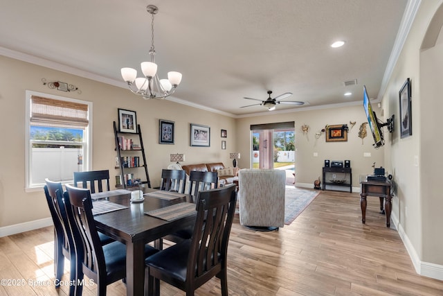 dining area featuring crown molding, light hardwood / wood-style flooring, and ceiling fan with notable chandelier