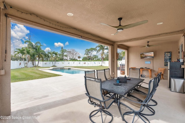 view of patio / terrace with ceiling fan and a fenced in pool