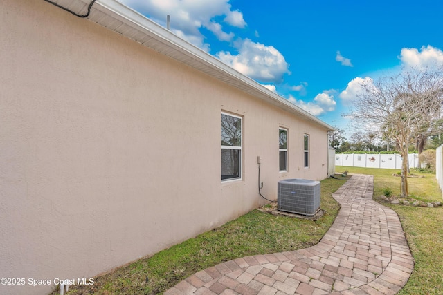 view of home's exterior with central AC unit, a yard, and a patio