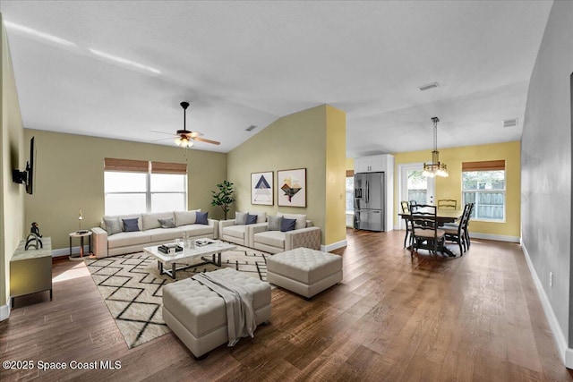 living room with ceiling fan with notable chandelier, lofted ceiling, and hardwood / wood-style floors