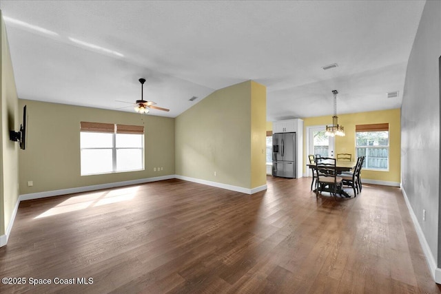 interior space featuring lofted ceiling, hardwood / wood-style floors, and ceiling fan with notable chandelier