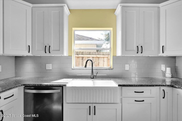 kitchen featuring sink, dishwasher, dark stone countertops, tasteful backsplash, and white cabinets