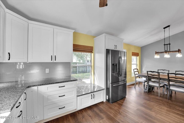 kitchen with lofted ceiling, hanging light fixtures, dark hardwood / wood-style floors, stainless steel refrigerator with ice dispenser, and white cabinets