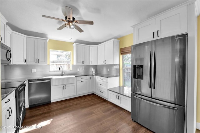 kitchen featuring stainless steel appliances, sink, white cabinets, and dark hardwood / wood-style flooring