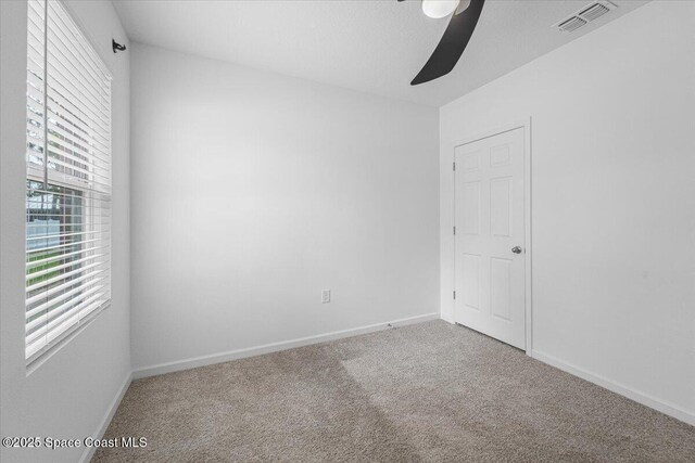 empty room with visible vents, baseboards, carpet, and ceiling fan