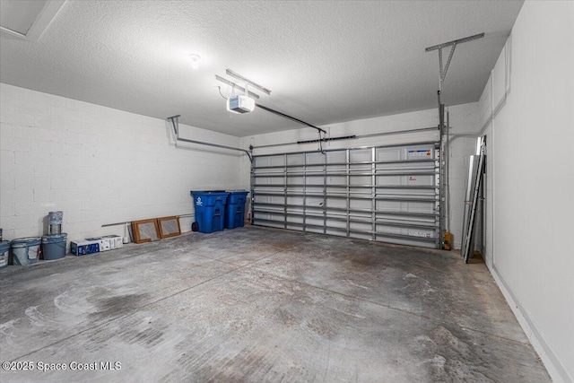 garage with a garage door opener and concrete block wall