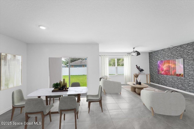 dining room featuring light tile patterned flooring, a textured ceiling, and an accent wall