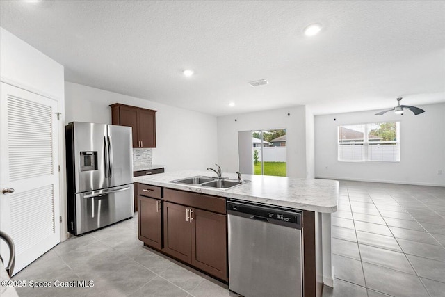 kitchen with tasteful backsplash, a healthy amount of sunlight, light countertops, stainless steel appliances, and a sink