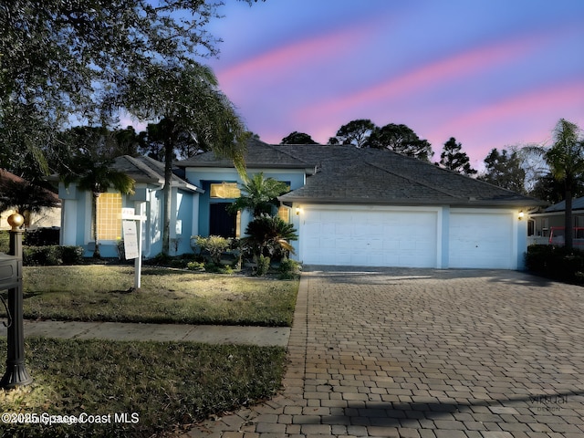 view of front facade with a yard and a garage