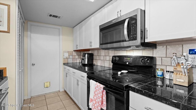 kitchen with white cabinetry, light tile patterned flooring, black range with electric cooktop, and tasteful backsplash