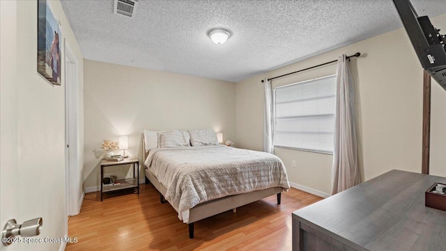 bedroom featuring a textured ceiling and light wood-type flooring