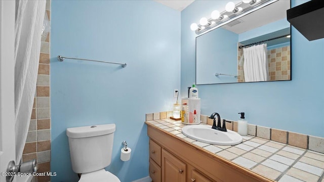 bathroom featuring a shower with curtain, vanity, and toilet