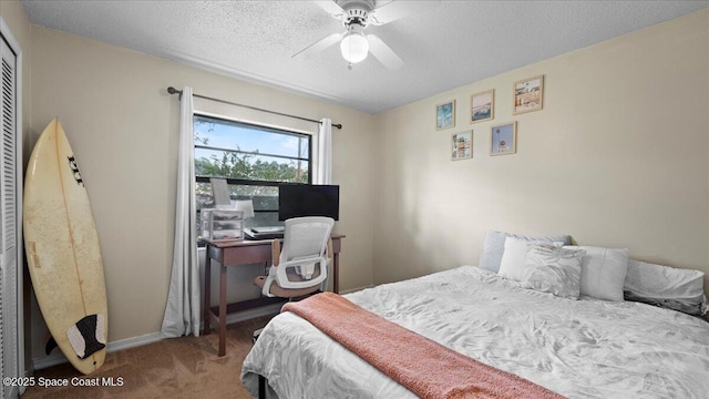 bedroom with ceiling fan, carpet flooring, and a textured ceiling