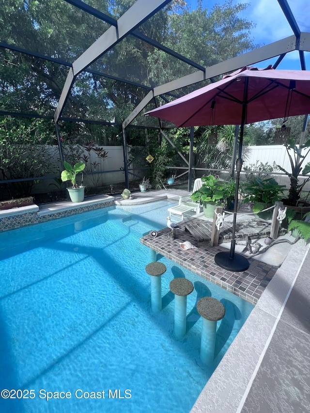 view of swimming pool featuring a patio area and glass enclosure