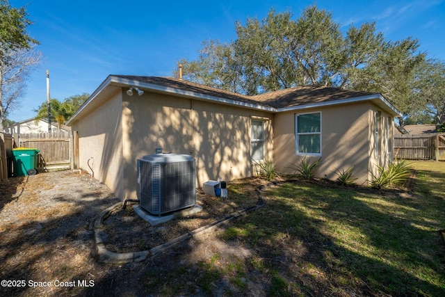 back of house featuring central AC and a lawn