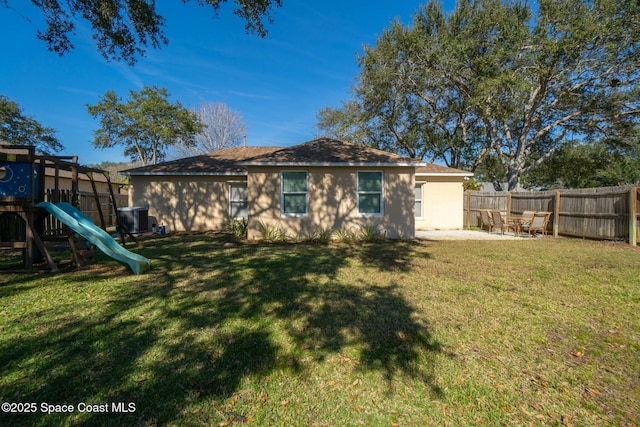 back of property with a playground, a patio, and a lawn