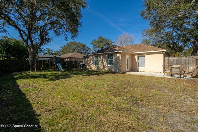 rear view of house featuring a playground, a patio area, and a lawn