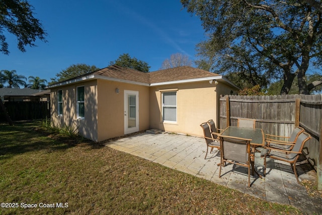 rear view of house featuring a yard and a patio area