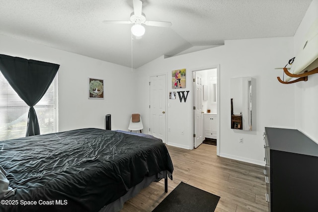 bedroom featuring lofted ceiling, ceiling fan, light hardwood / wood-style flooring, and a textured ceiling