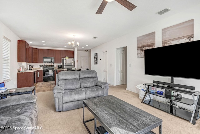 carpeted living room with ceiling fan with notable chandelier