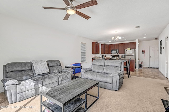 living room featuring light carpet and ceiling fan with notable chandelier